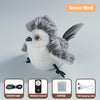 A fluffy gray and white bird toy with a black beak and wings, shown next to its remote control and charging cable.