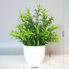 A vibrant green artificial bonsai plant in a white pot, shown from the front.