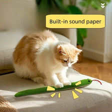 Un chat orange et blanc duveteux joue avec un jouet à crissement vert.