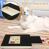 Ein weißer Hund liegt auf einer gestreiften Matte neben einem Holz-Hundnagelbrett mit einer geöffneten Snackbox.