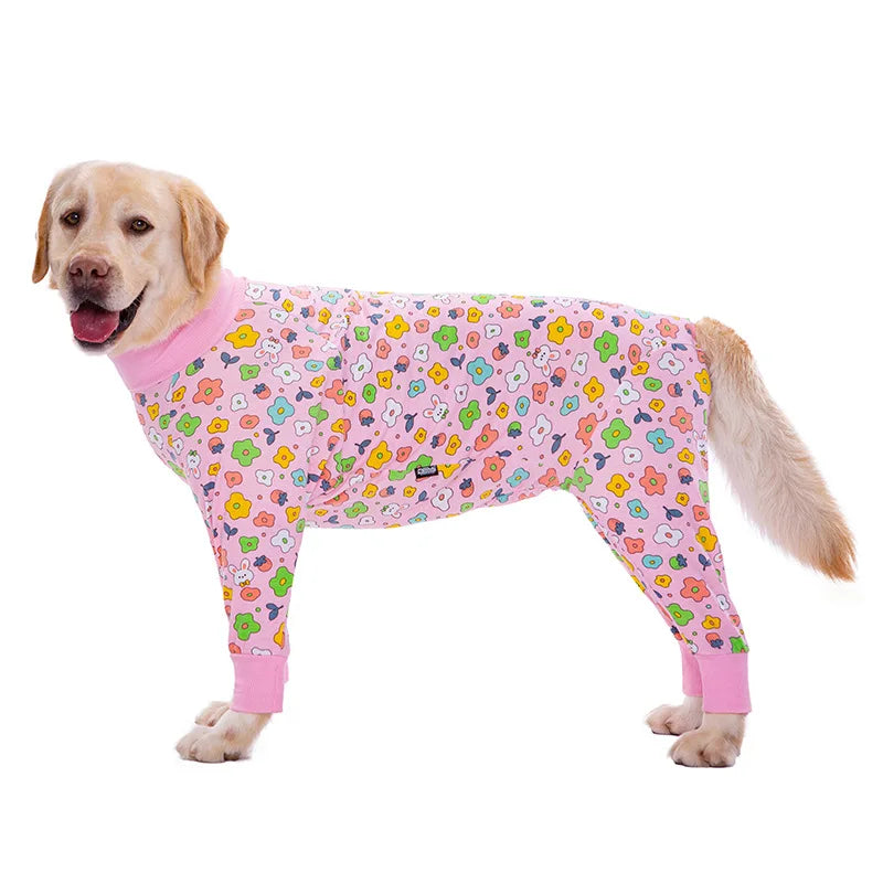 A golden retriever wearing a pink cartoon animal print jumpsuit.
