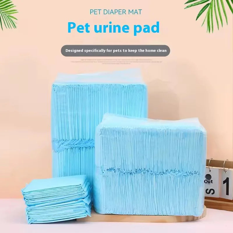 Une pile de lingettes pour urine et de tapis d'entraînement bleu clair sur une surface en bois.
