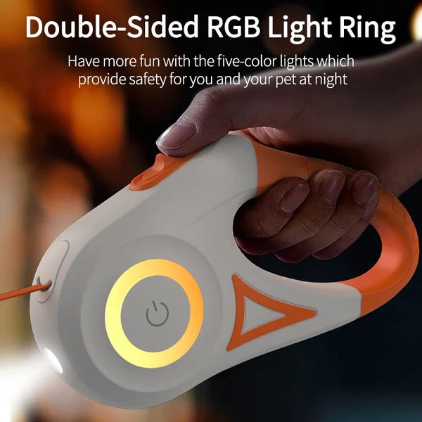 A hand is holding an orange and white double-sided RGB light ring device for pet safety.