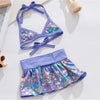 A purple and iridescent summer pet swimsuit for dogs and cats lying on a white surface.
