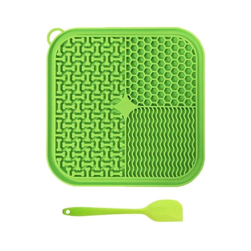 A bright green silicone licking mat for pets with suction cups and a matching spoon.