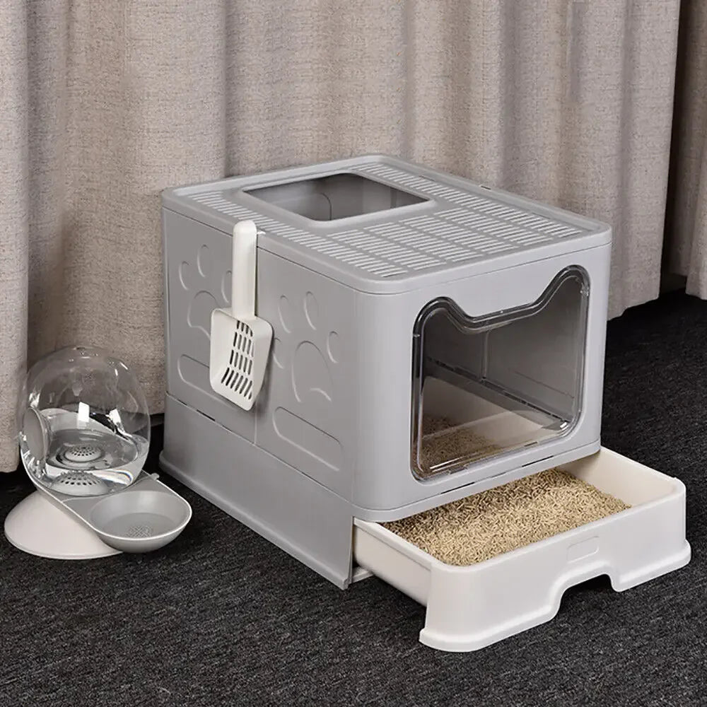 A gray foldable cat litter box with a front entry and top exit, shown on a dark surface.