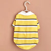 A yellow and white striped polo shirt for a small dog is displayed on a hanger.