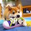 A small orange dog toy shaped like a slipper with a rope for chewing and squeaking.