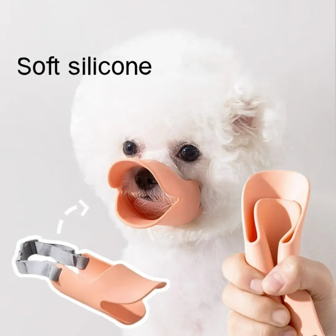 A small white dog wearing a soft silicone duckbill muzzle, shown with an inset of the adjustable silicone piece.