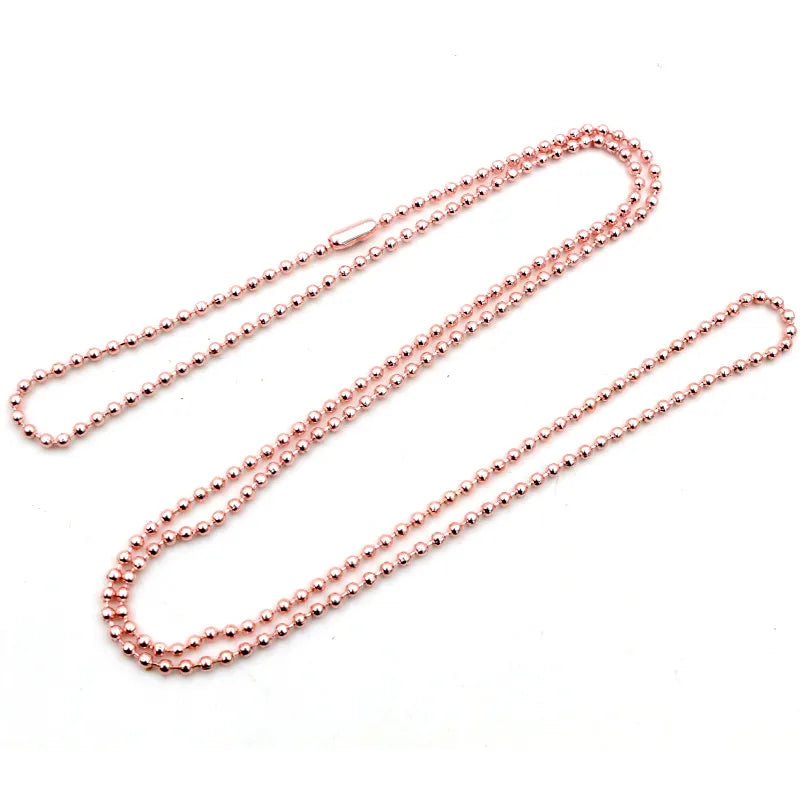 A set of delicate rose gold plated ball bead necklaces laid out on a white background.