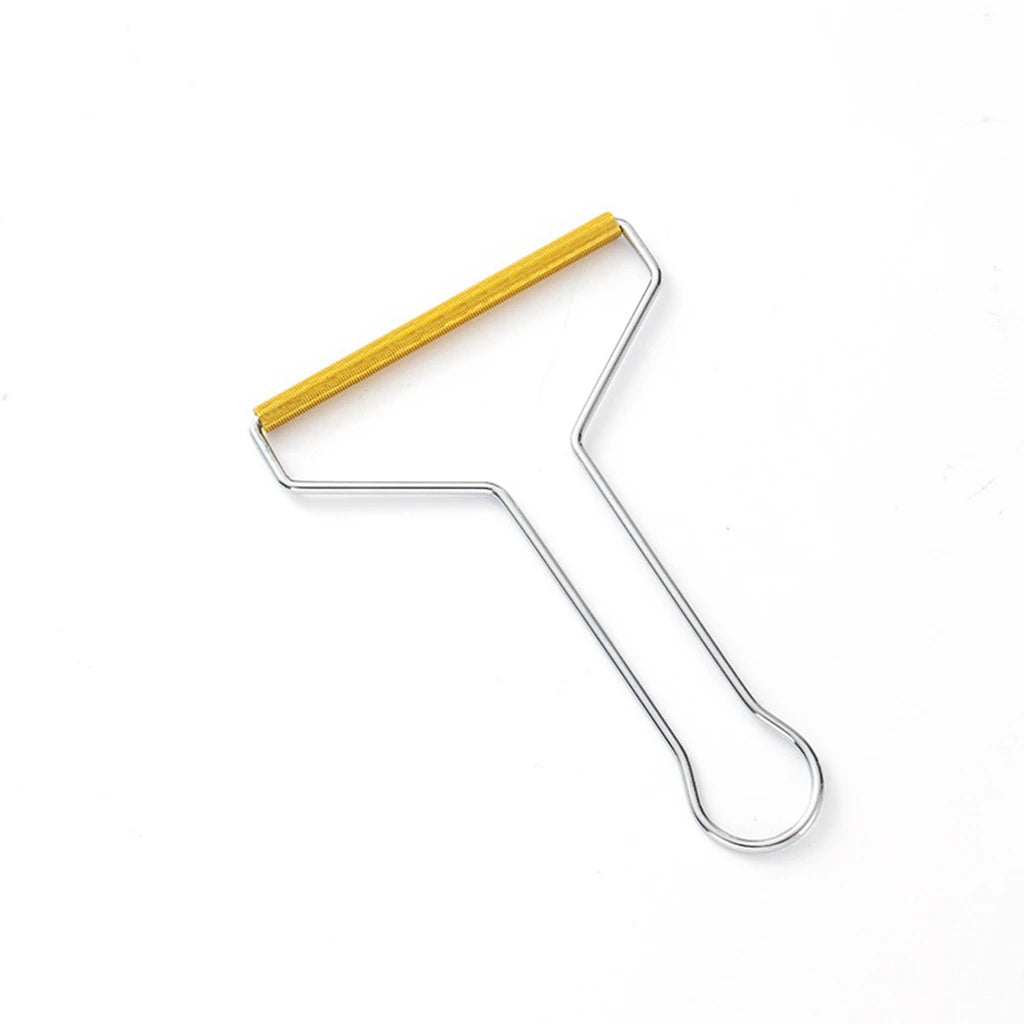A manual lint remover brush with a gold-colored handle and silver metal frame.