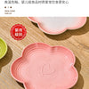 Bol à animaux en céramique rose avec des côtes et un motif cœur posé sur une surface en bois.