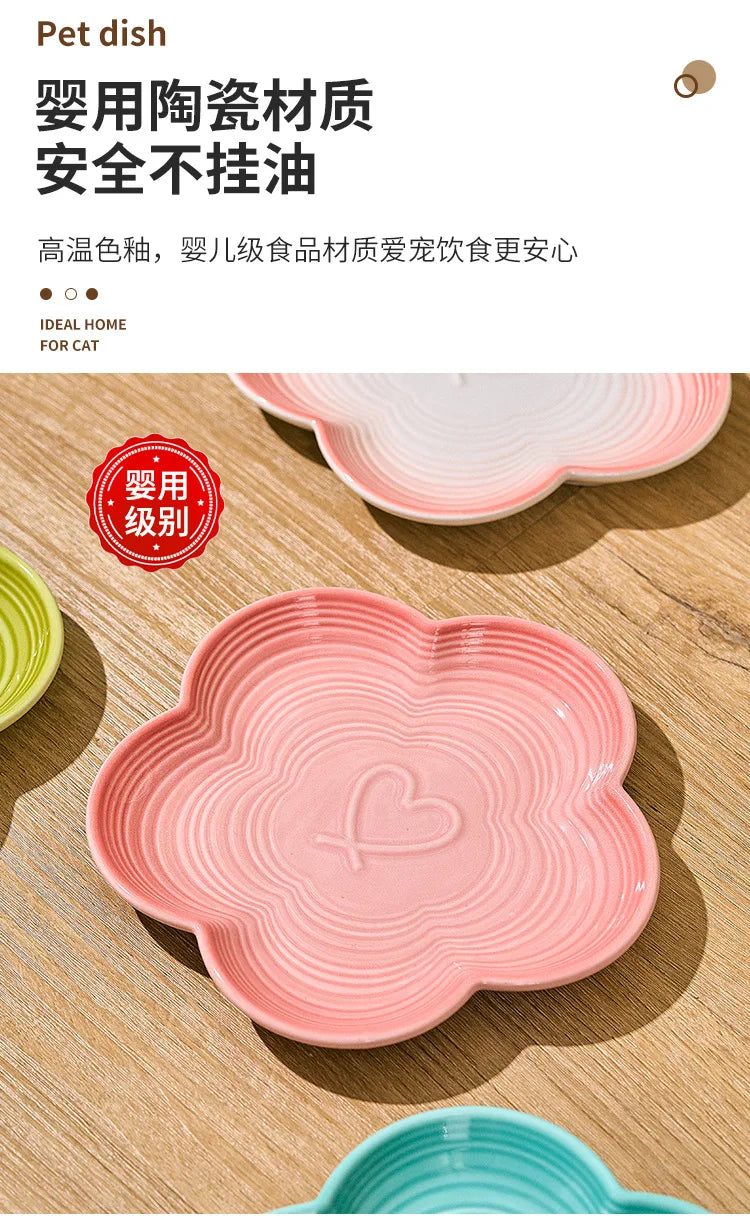Bol à animaux en céramique rose avec des côtes et un motif cœur posé sur une surface en bois.