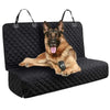 A German Shepherd dog is lying on a black waterproof car seat cover mat.