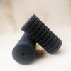 A stack of black biological aquarium sponge filters, showing their ribbed texture and cylindrical shape.