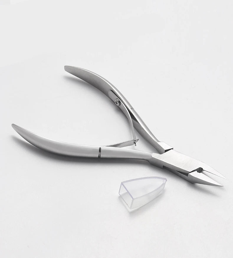 A pair of precision stainless steel cuticle nippers with a clear tip resting on a white surface.