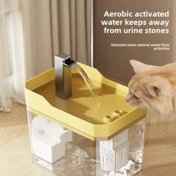A yellow automatic water fountain for cats with a stream of water, placed inside a clear container.