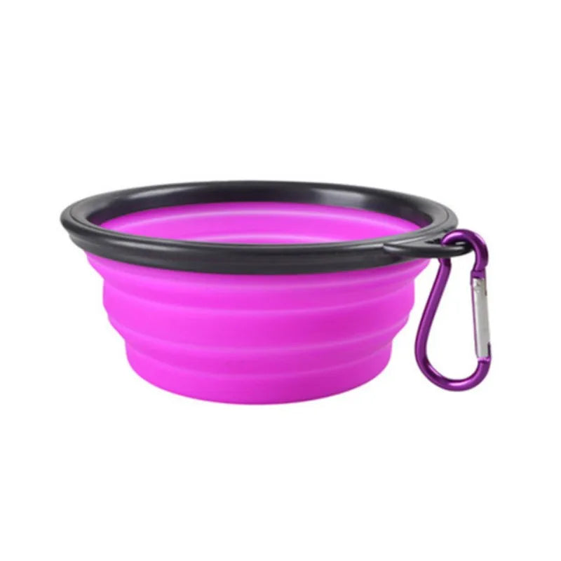 A bright pink collapsible silicone pet travel bowl with a black rim and attached strap.