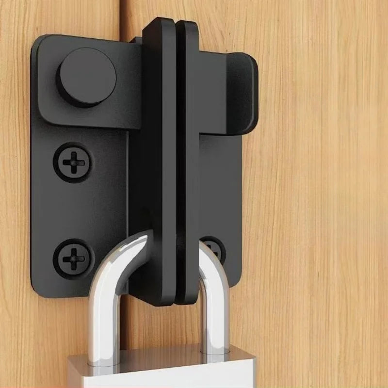 A black sliding bolt lock mounted on a wooden surface, featuring a silver-colored hasp.