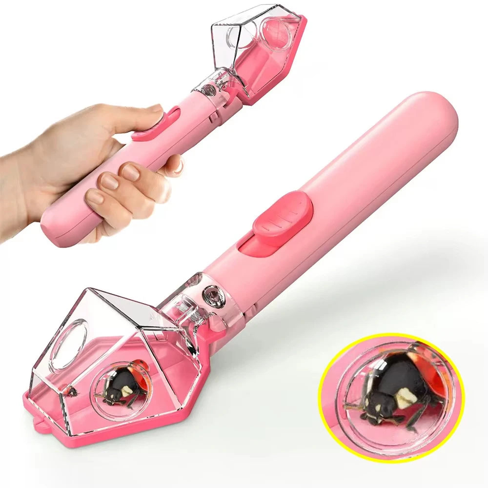 A pink portable handheld insect catcher with a clear plastic collection chamber is shown being held by a hand.