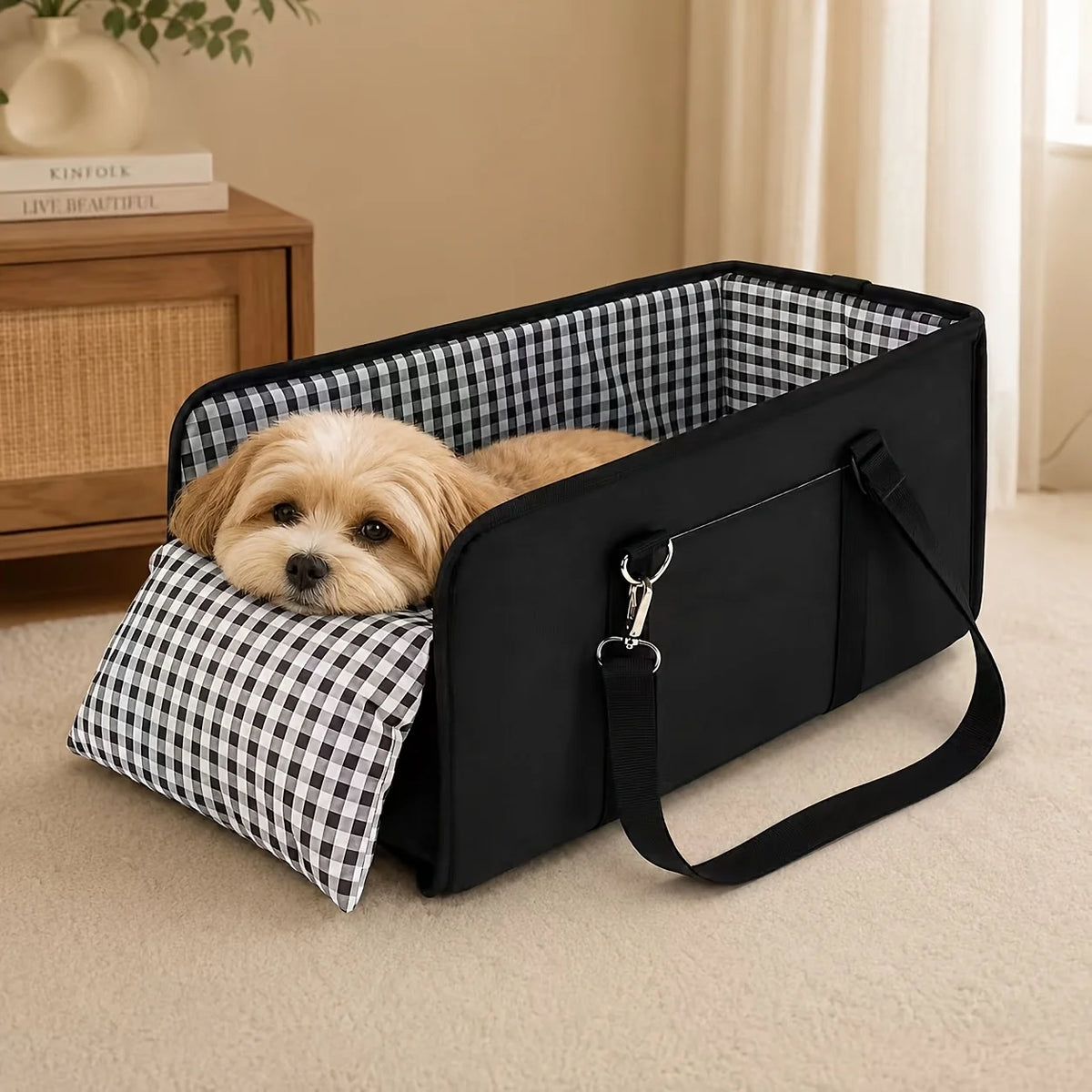 A black foldable dog car seat with a checkered fabric lining and a small dog resting inside.