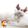 Gato blanco vistiendo un traje navideño con Santa, astas de ciervo y accesorios de cachorro.
