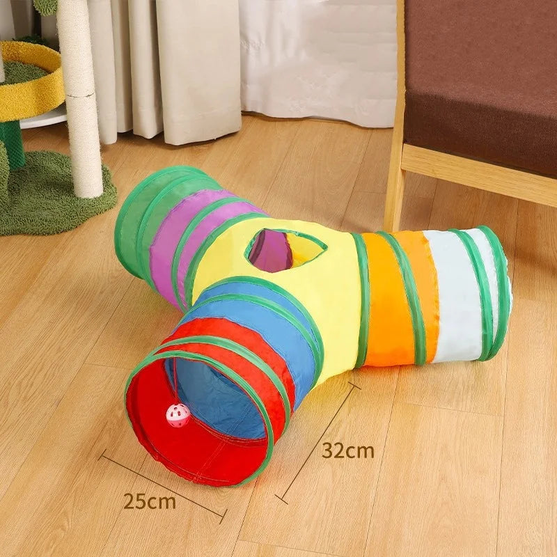 Buntes, zylindrisches, zusammenklappbares Hundetunnel für Indoor- oder Outdoor-Spiele auf einem Holzboden.