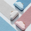 Three cloud-shaped lint roller refills in light blue, white, and pink resting on a pastel background.