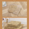 A display of natural straw woven mats stacked and spread out on a wooden surface.