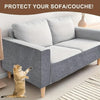 Graues Sofa mit weißen Kissen und einer Katze auf einem gestreiften Teppich.