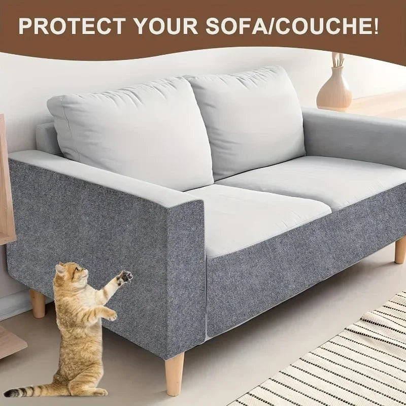 Graues Sofa mit weißen Kissen und einer Katze auf einem gestreiften Teppich.
