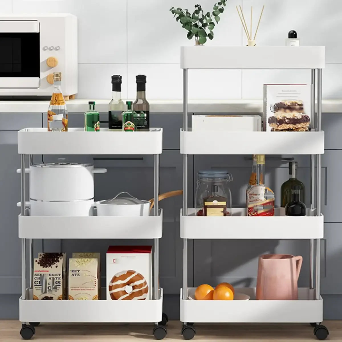 A white mobile storage rack with multiple tiers holding kitchen items like bottles, containers, and food products.
