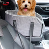 A golden-colored dog is resting in a gray portable pet car bed with safety straps inside a car.