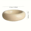 A smooth, beige ceramic donut cat bowl with a wide rim and a slight concave shape.