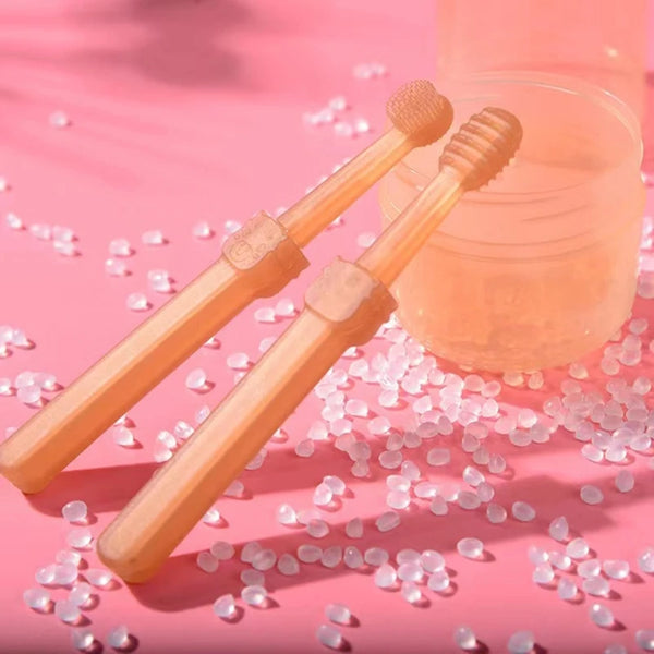 A silicone pet toothbrush set for cats and dogs with bristles is shown next to a clear storage case on a pink background.