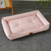 A pink premium corduroy pet sofa bed for dogs and cats lying on a gray carpet.