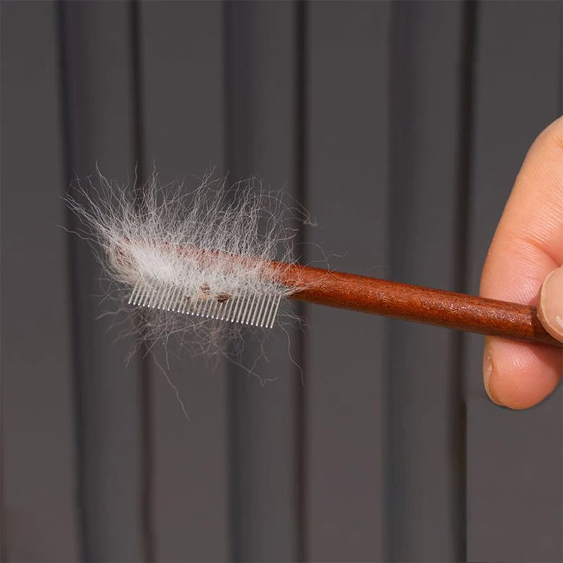 Hand holds a wooden comb with bristles, showing wispy white fibers, for facial and hair cleaning.