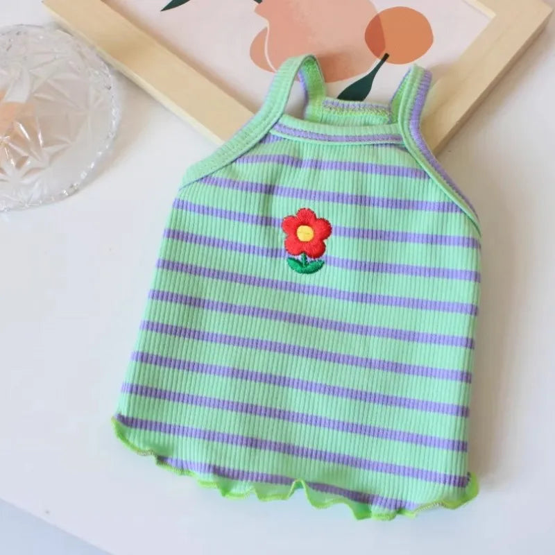 A lime green and purple striped dog vest with a red flower appliqué.