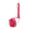 A pink silicone pet bath brush with a dispenser for shampoo is shown against a white background.