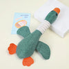 A soft plush dog toy resembling a green snake with orange accents, resting on a white box.