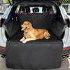 A golden retriever dog is resting on a black waterproof car seat cover inside the trunk of a vehicle.