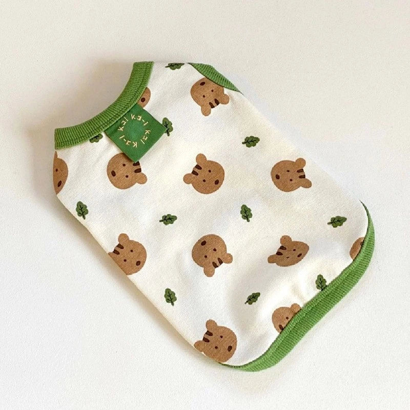 White fabric vest with brown cartoon dog prints and green trim.