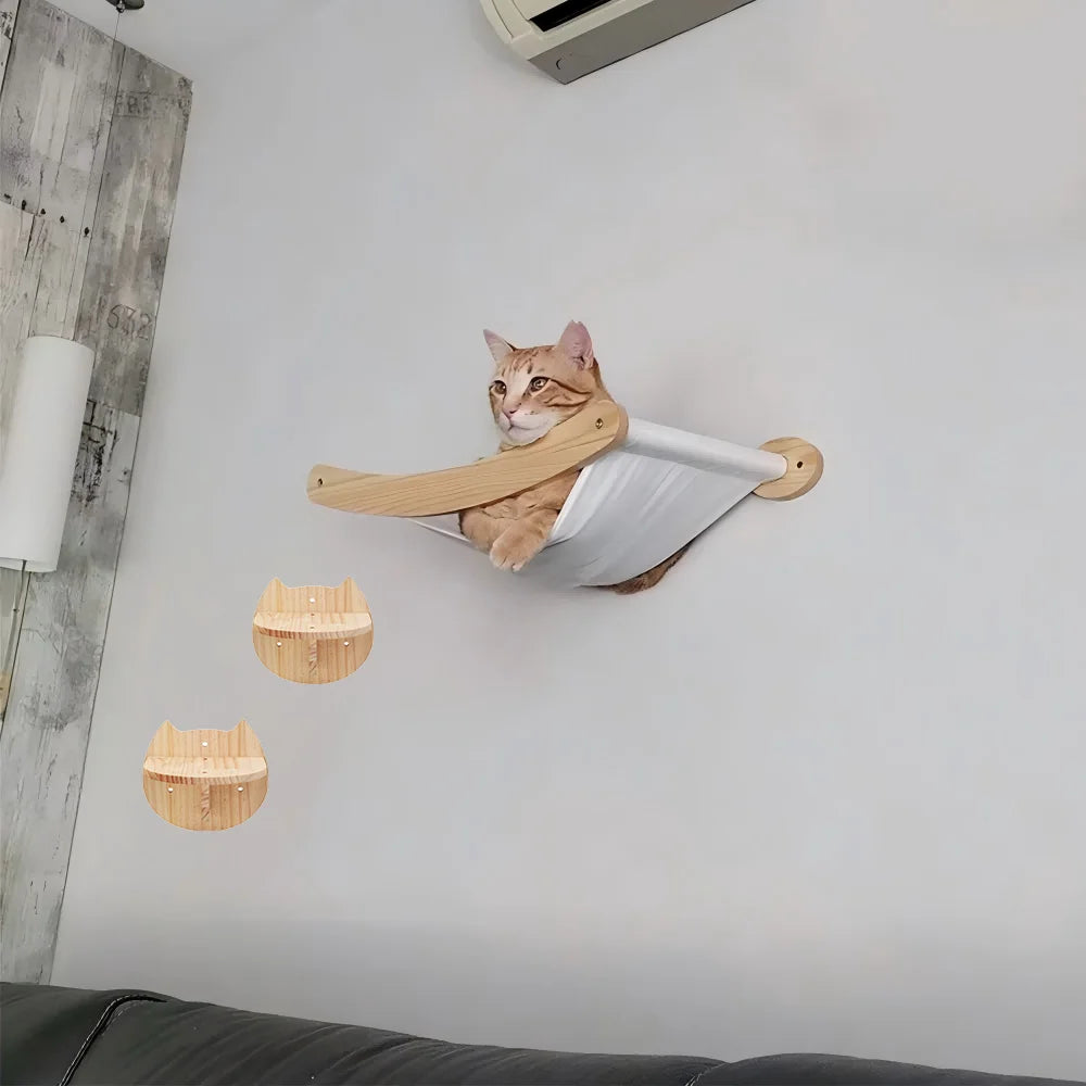 An orange tabby cat is resting on a wall-mounted wooden hammock and climbing shelf.