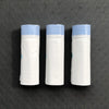 Trois rouleaux de sacs de littere en tissu blanc épais avec des dessus bleu clair, exposés sur une surface sombre.