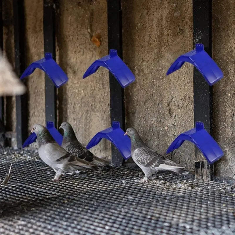 A set of plastic bird rest stands is shown with several pigeons on a wire mesh surface.