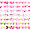 A collection of pink and multicolored pet hair bows with gentle rubber bands.