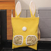 Un sac de foin jaune avec des éléments blancs est exposé dans un contenant sombre.