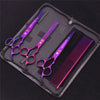 A set of professional stainless steel pet grooming scissors in purple and pink are displayed inside a black zippered case.