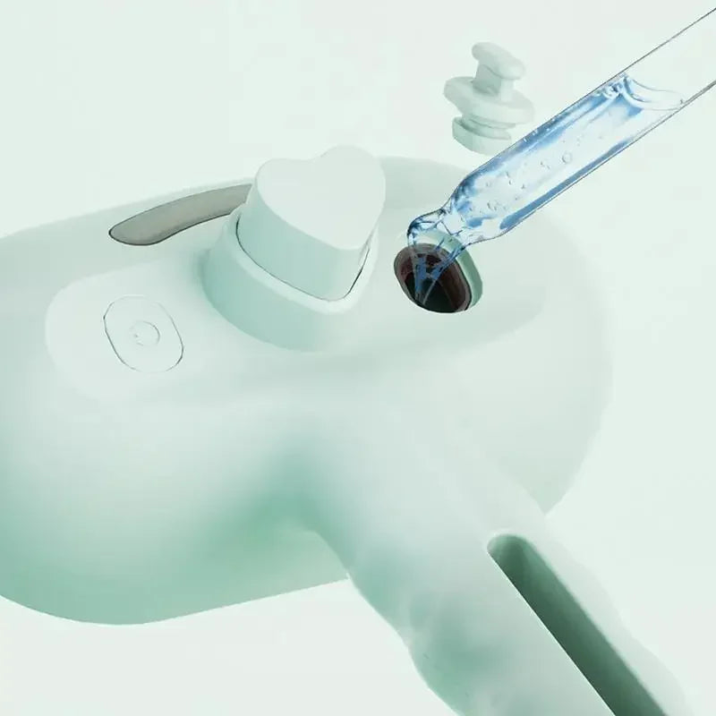Una mano usa líquido azul para aplicar peine y cepillo de vapor para un cuidado suave en un dispositivo blanco.