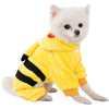 A small white dog wearing a yellow fleece jumpsuit with black stripes and an orange collar.